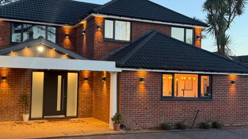 a brick house with a black roof at Lux 7 Bedroom residence in Waterlooville
