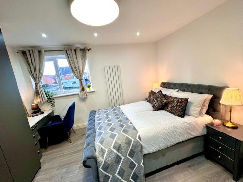 a bedroom with a bed and a desk and a window at Lux 7 Bedroom residence in Waterlooville