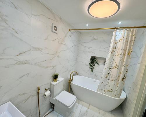 a bathroom with a tub and a toilet and a sink at Lux 7 Bedroom residence in Waterlooville