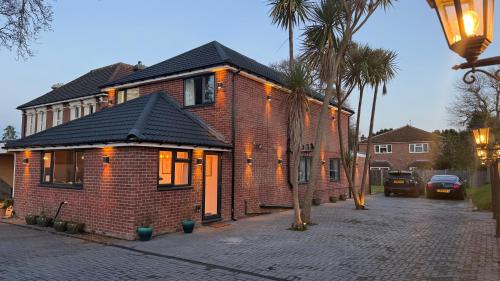 a brick house with a black roof on a street at Lux 7 Bedroom residence in Waterlooville