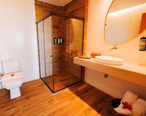 a bathroom with a shower and a toilet and a sink at Almareia Boutique Hotel in Praia dos Carneiros