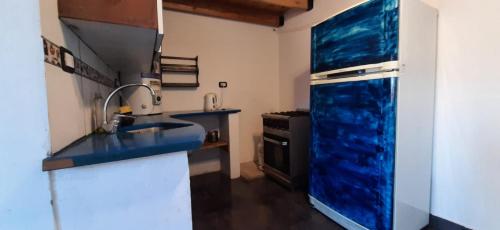 a blue kitchen with a sink and a refrigerator at DiversidadMDP in Mar del Plata