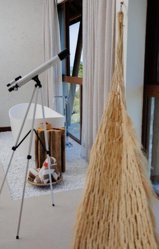 a telescope sitting on a tripod next to a room at Almareia Boutique Hotel in Praia dos Carneiros