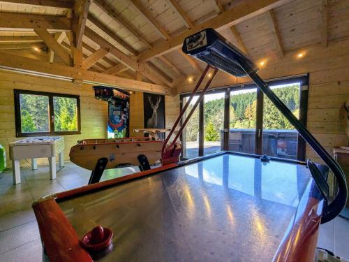 - une table de ping-pong au milieu d'une pièce avec un billard dans l'établissement Chalet familial spacieux avec spa, sauna et salle de jeux - FR-1-589-750, à Ban-sur-Meurthe-Clefcy