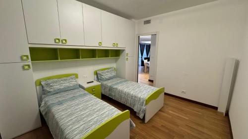 two beds in a room with white cabinets at 085 luxury apartment in Montesilvano