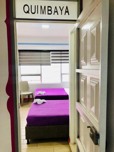 a small bedroom with a purple bed in a room at Hotel Café Color in Armenia