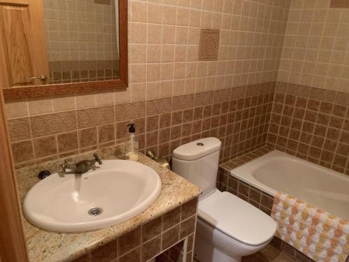a bathroom with a sink and a toilet and a tub at Casa Rural Los Tasajos in La Horcajada