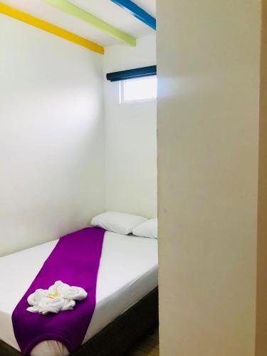 a bedroom with a bed with a purple blanket at Hotel Café Color in Armenia