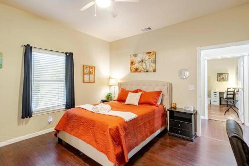 a bedroom with a bed with orange sheets and a window at Private Rooms in San Antonio Home 5 mins to downtown in San Antonio