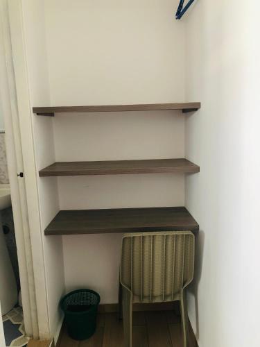 a shelf in a room with a chair and a stool at Hotel Café Color in Armenia
