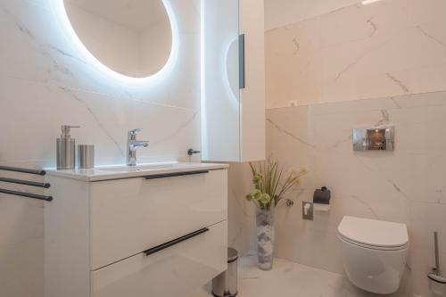 a white bathroom with a sink and a toilet at KARINA APARTMAN in Dunajská Streda