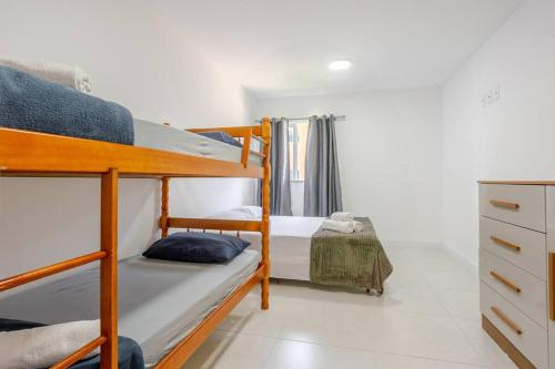 a bedroom with two bunk beds and a dresser at Apto 1 quarto no Golden Lake! in Arraial do Cabo