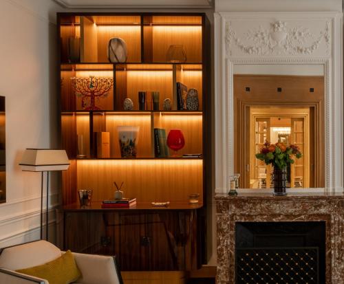 un salon avec une cheminée et une étagère à livres dans l'établissement HIGHSTAY - Luxury Serviced Villa - Poincaré, à Paris