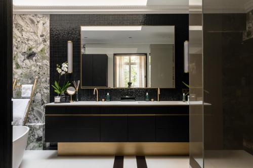 une salle de bain avec un lavabo et un miroir dans l'établissement HIGHSTAY - Luxury Serviced Villa - Poincaré, à Paris