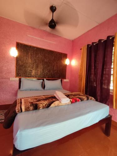 a bedroom with a large bed with pink walls at House Of Munnar in Anachal