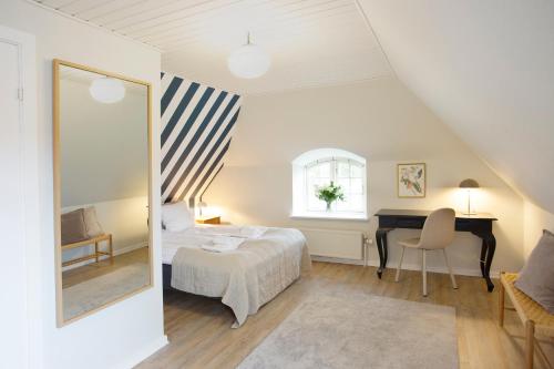 a bedroom with a bed and a desk and a mirror at HotelVFjorden in Lemvig