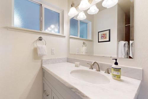 a white bathroom with a sink and a mirror at Lavender Hollow in Bend