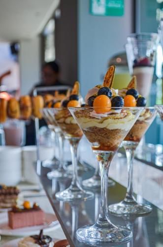 Eine Reihe von Gläsern, gefüllt mit Desserts, auf einem Tisch in der Unterkunft Swissotel Santa Cruz de La Sierra in Santa Cruz de la Sierra