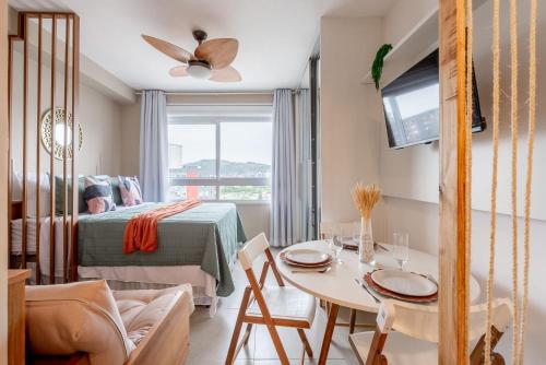 a bedroom with a bed and a table with a dining room at Connect by LikeHome in Porto Alegre