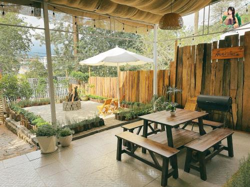 a patio with two picnic tables and an umbrella at Ann's Home I in Khu Chi Lăng