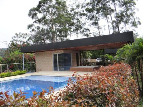 a house with a swimming pool in front of it at Libertg Hotels Medellin in Copacabana