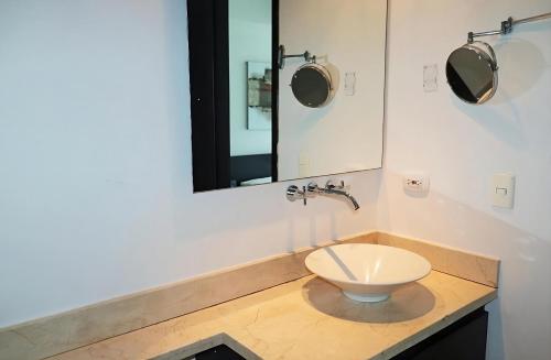 ein Badezimmer mit Toilette und Spiegel in der Unterkunft Lodging Apartamento 1 Frente a la Playa in Cartagena de Indias