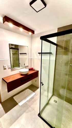 a bathroom with a sink and a glass shower at Villa Biju in Jericoacoara