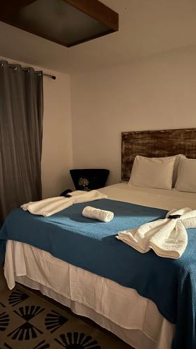 a bedroom with a bed with a blue blanket at Villa Biju in Jericoacoara