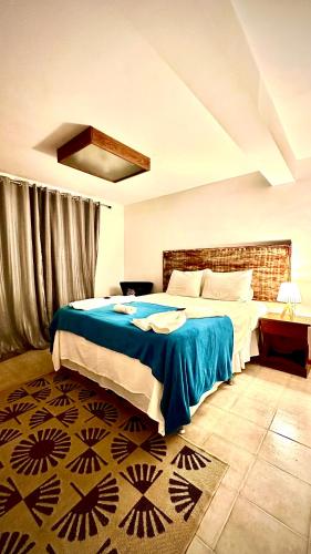 a bedroom with a large bed with a blue blanket at Villa Biju in Jericoacoara