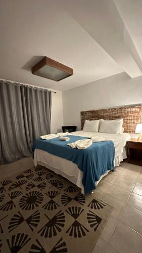 a bedroom with a bed with a blue blanket at Villa Biju in Jericoacoara