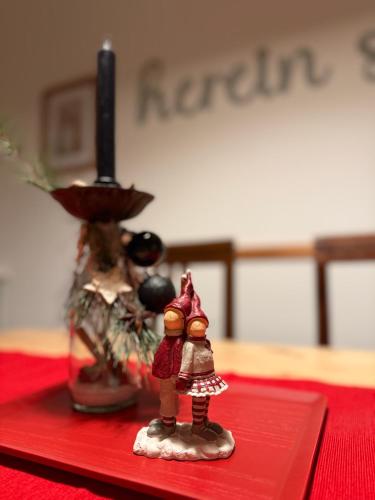 two figurines of a couple standing on a red table at Viki54 FeWo04 "hereinspaziert", Monteurs- und Ferienwohnung in Velten
