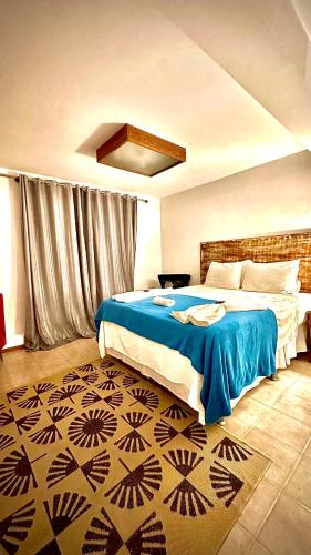 a bedroom with a large bed with a blue blanket at Villa Biju in Jericoacoara