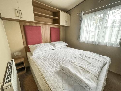 a bedroom with a large white bed with a window at Marie Helene, 58 Mallard Carlton Meres Holiday Park in Kelsale
