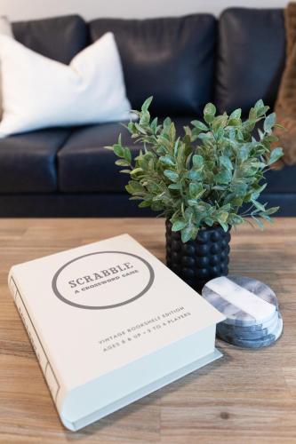 a book on a table with a vase with a plant at Luxury Apartment in Downtown SLC in Salt Lake City