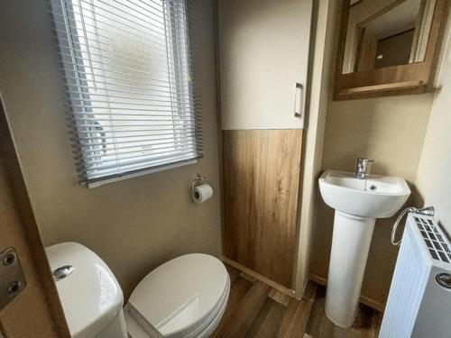 a small bathroom with a toilet and a sink at Marie Helene, 58 Mallard Carlton Meres Holiday Park in Kelsale
