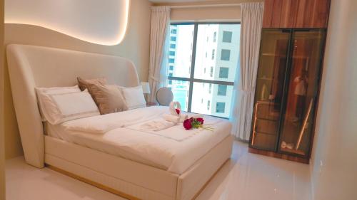 a bedroom with a white bed with a flower on it at USMANS 3 Bedroom Apartment all Rooms Sea View Direct Beach Access Daily HOUSEKEEPING JBR in Dubai