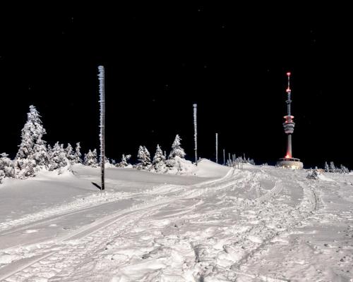 a snow covered road with a pole in the distance at Chaty Malá Morávka in Bruntál