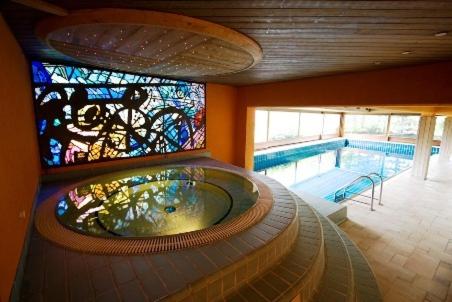 a swimming pool with a tub with a stained glass window at Hotel Pavillon in Courmayeur