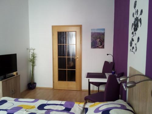 a bedroom with a bed and a desk and a door at Apartmány - Penzion Smetanka in České Budějovice