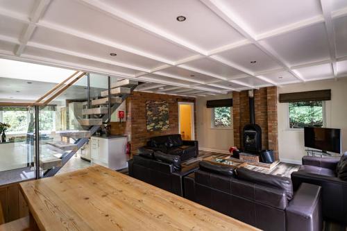 a living room with a couch and a table at Dimmingsdale, woodland lodge with hot tub for 8 in Oakamoor