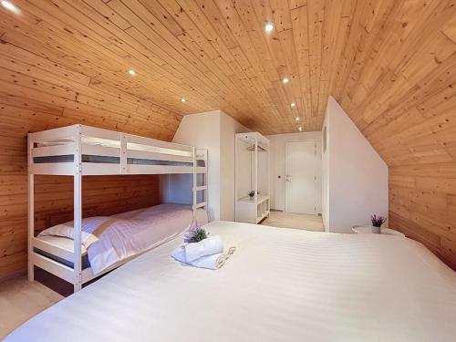 a bedroom with a bunk bed with a wooden ceiling at Villa Zonnedauw - Koksijde in Koksijde
