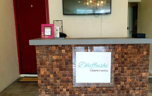 a brick counter with a sign on it at Dhiffushi Tourist Hotel in Dhiffushi