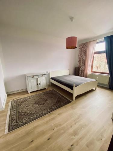 a bedroom with a bed and a rug at Helle geräumige Altstadtwohnung am Hagentor in Neuhaldensleben