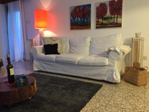 a white couch in a living room with a bottle of wine at Nikolas and Persefoni Flats in Yeroskipou