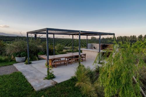 a picnic table under a canopy in a garden at Casa de Uco Vineyards and Wine Resort in Los Árboles
