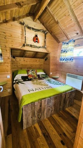 une chambre avec un lit dans une cabane en rondins dans l'établissement Gîte de France La cabane du causse 1 étoile - Gîte de France 2 personnes MAE-6394, à Lissac-sur-Couze