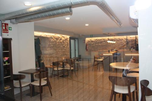 a restaurant with tables and chairs in a room at Xanela Xures in Muiños