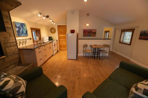 a kitchen and living room with a refrigerator and a table at Located in Downtown Whitehorse - Treehouse in Whitehorse