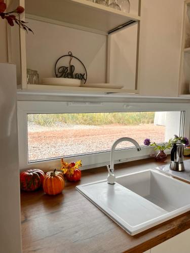 a kitchen counter with a sink and a window at Domki Granero w Górach Sowich in Grzmiąca
