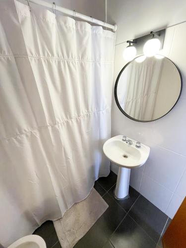 a bathroom with a white shower curtain and a sink at Saavedra 118 1°H by depptö in Bahía Blanca